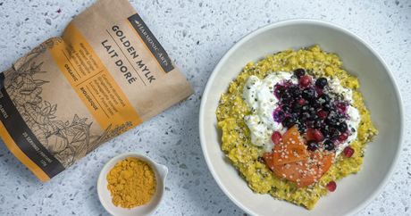 Image features a bag of Harmonic Arts Golden Mylk Herbal latte next to a bowl of the High Protein Golden Mylk Oatmeal.